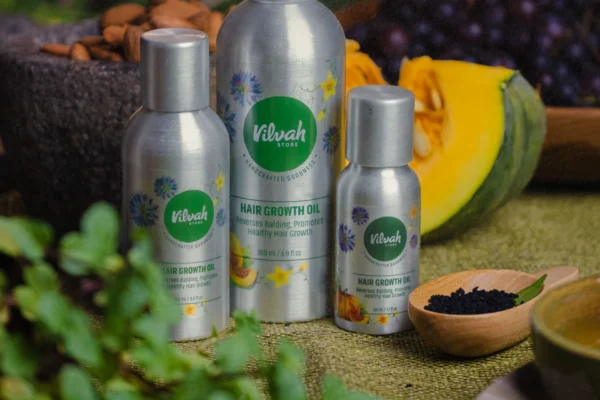 Butelki z organicznym olejkiem do włosów, obok nasiona i orzechy, naturalne składniki.